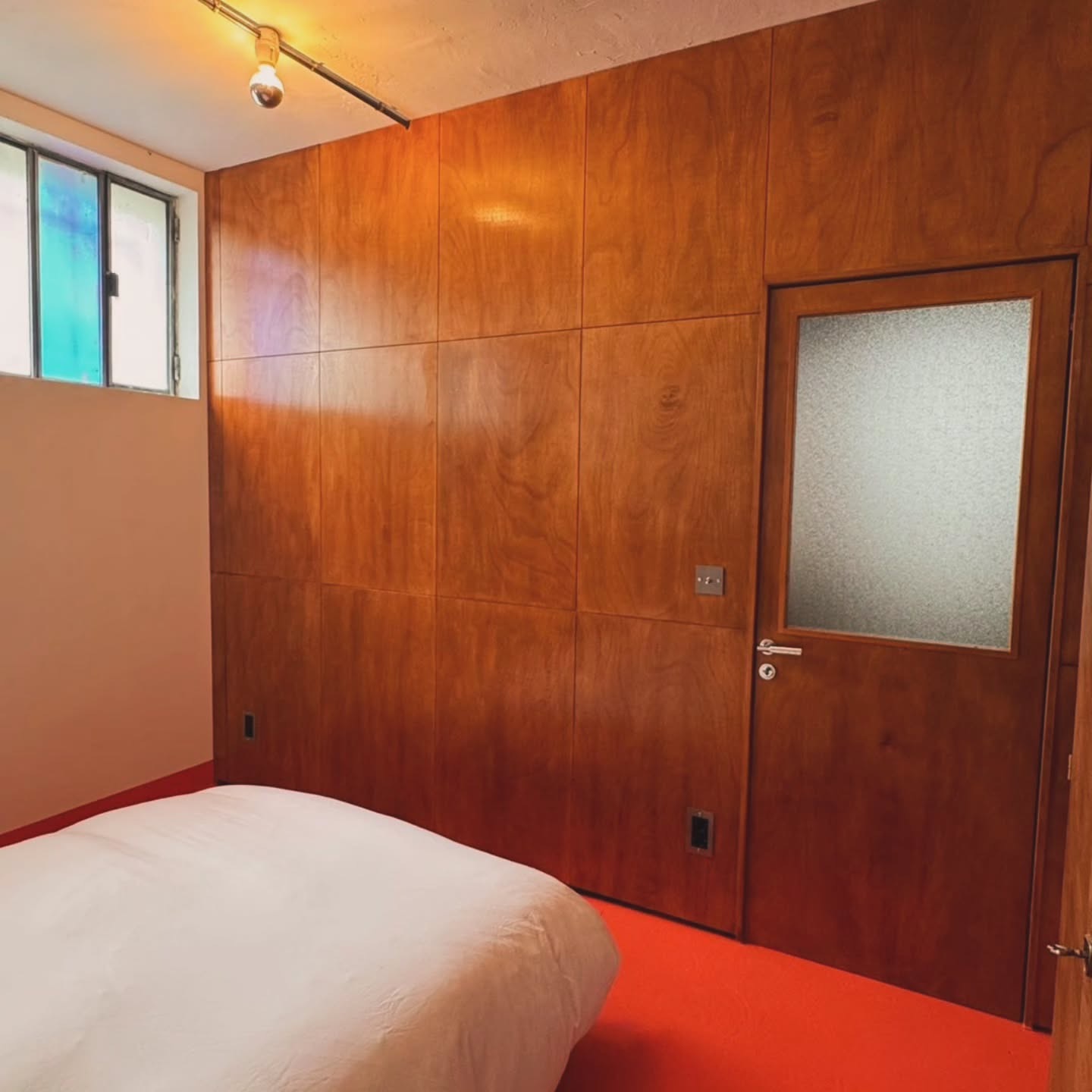 Mur de chambre en boiserie avec porte vitrée et imposte