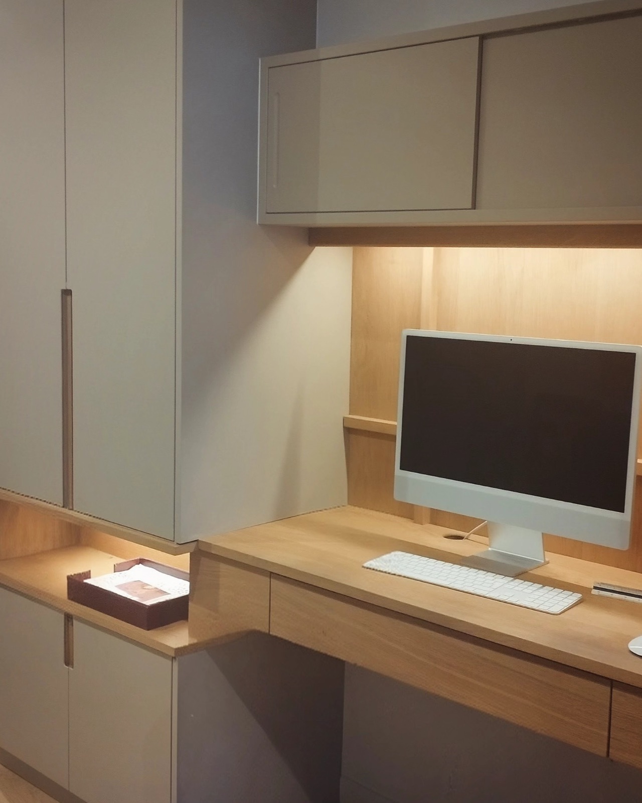 Bureau intégré sur mesure entre deux placards, plan de travail en bois et éclairage