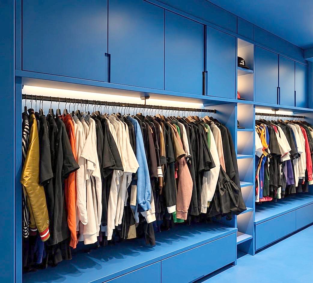 Dressing sur mesure bleu avec penderies éclairées par LED, colonne d'étagères et rangements hauts
