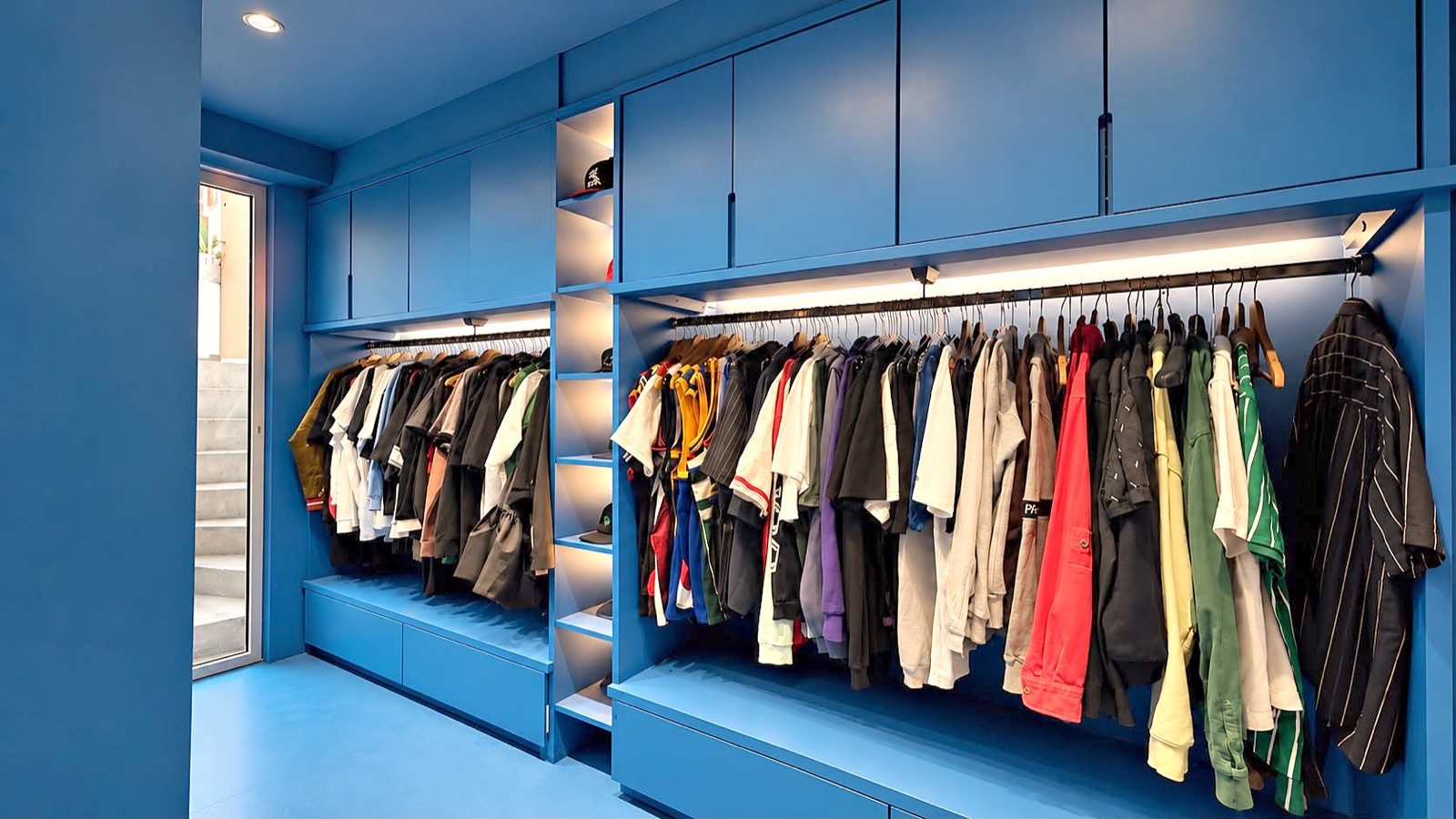 Vue d'ensemble d'un dressing sur mesure bleu avec éclairage LED