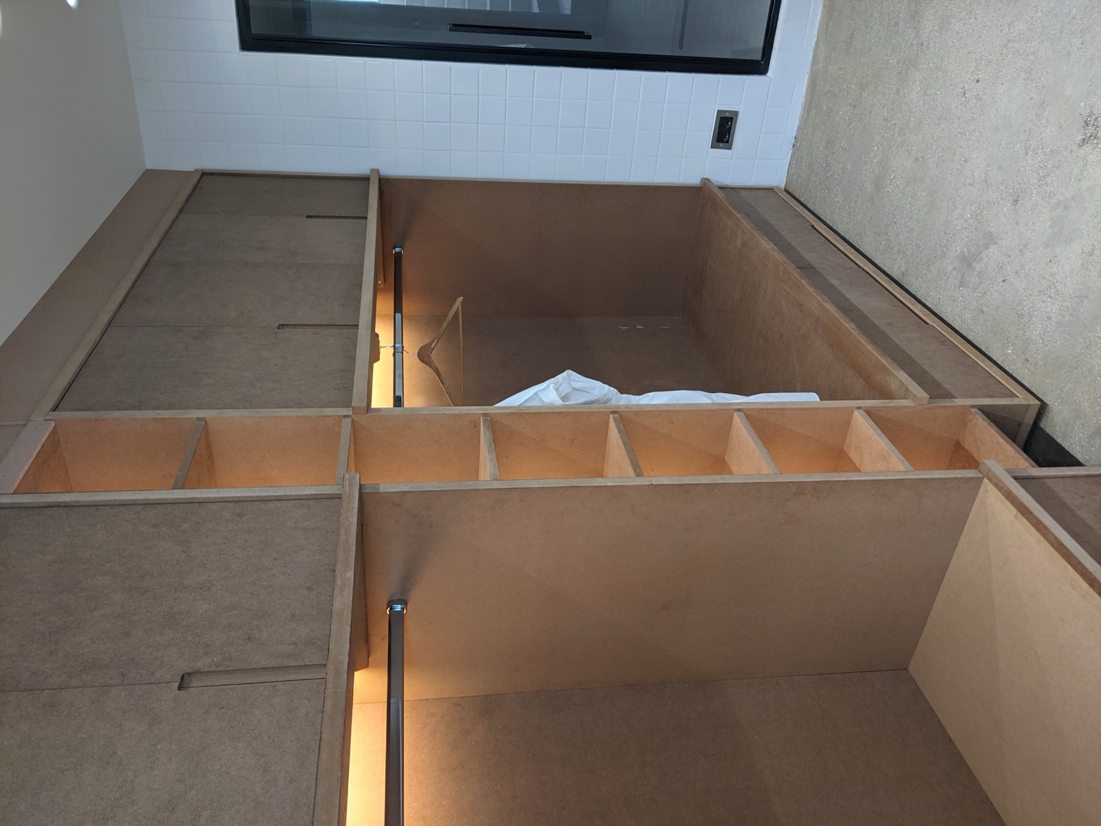 Dressing sur mesure en cours de finition : penderies, colonne d'étagères et banc à tiroirs