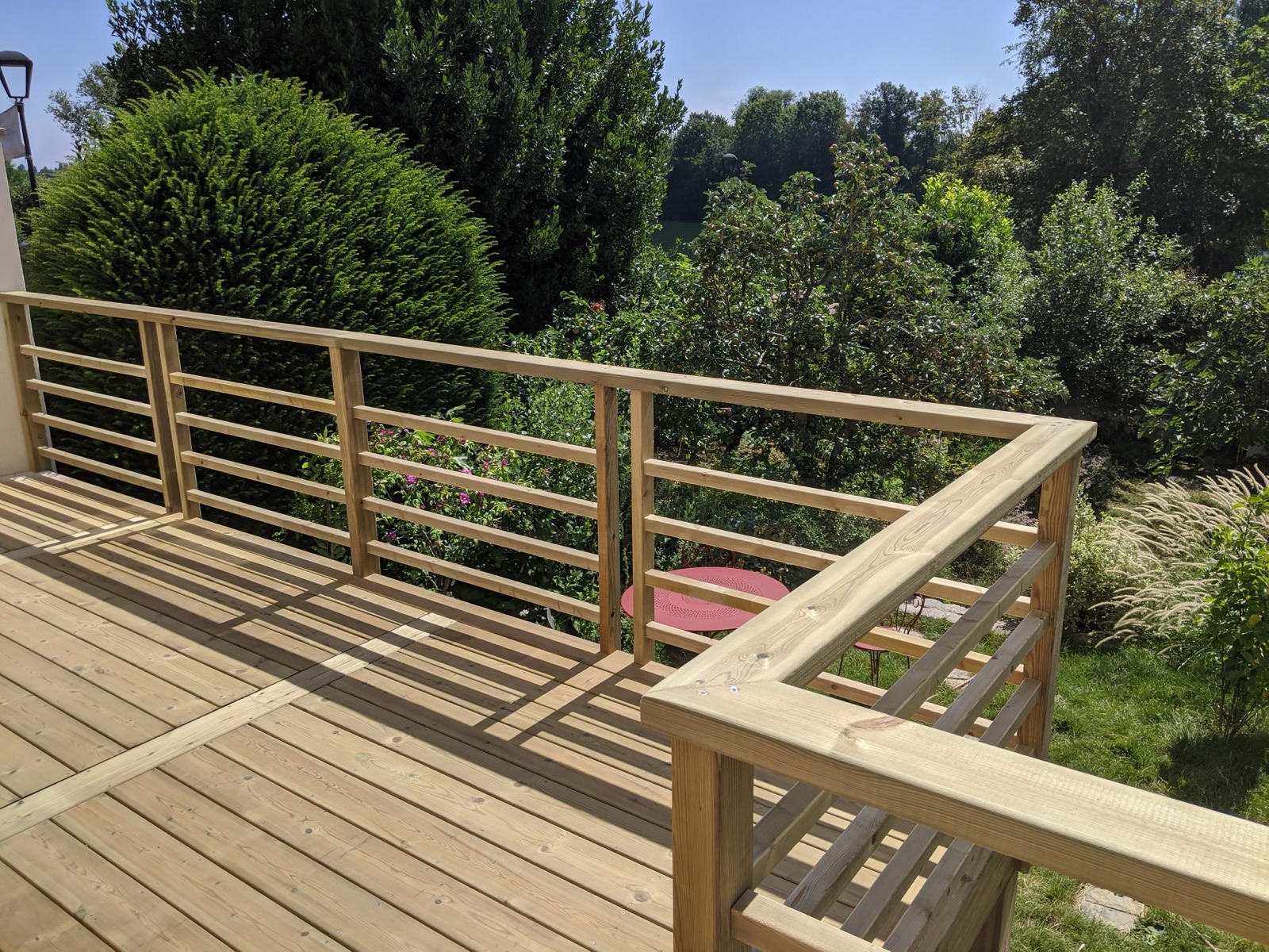 Angle de garde-corps bois d'une terrasse suspendue face à la végétation